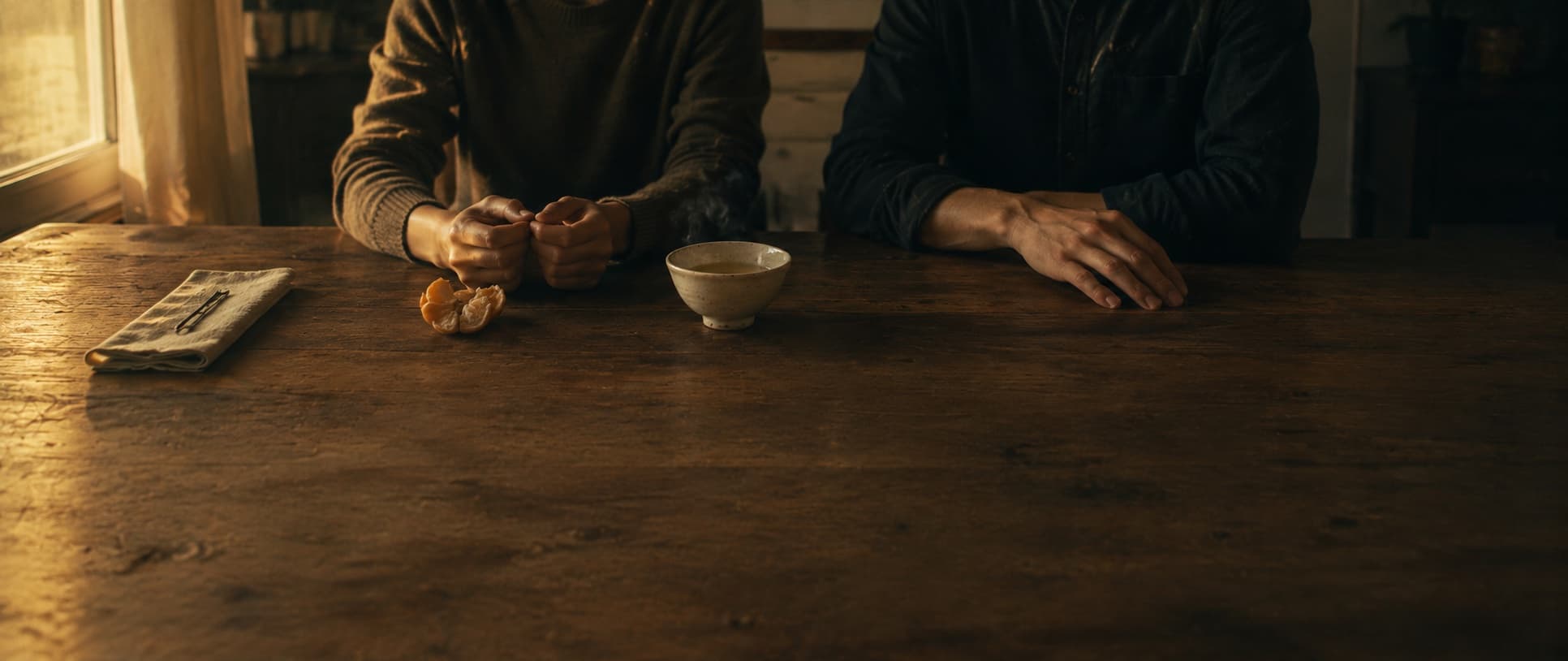 Two people sitting quietly at a table before either speaks